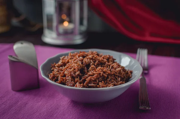 Тарелка коричневого риса на красивом фиолетовом столе — стоковое фото