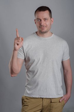 Hafif rahat T-shirt gri bir bac üzerine bir yakışıklı, kaslı adam