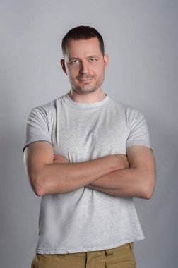 Hafif rahat T-shirt gri bir bac üzerine bir yakışıklı, kaslı adam