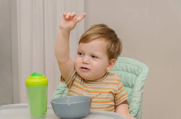 Petit garçon blond dans un t-shirt rayé ne veut pas manger une por — Photo