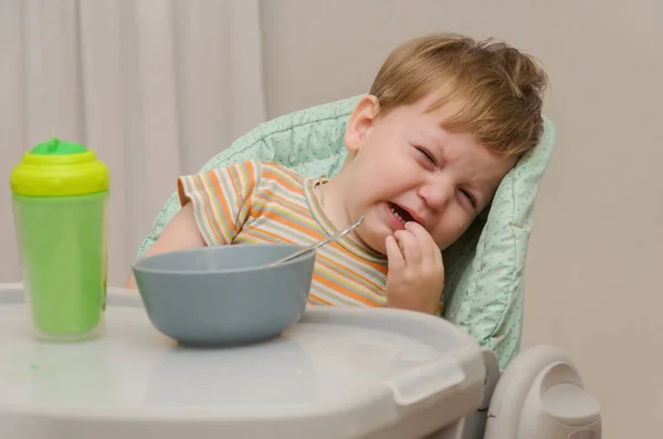 Petit garçon blond dans un t-shirt rayé ne veut pas manger une por — Photo