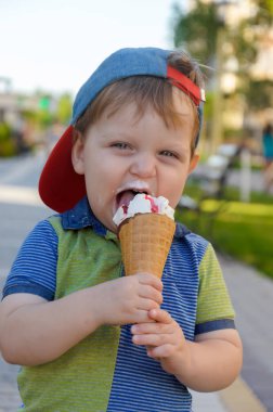 Sevimli küçük çocuk bir Dondurma külahı çilek reçeli ile tutarak 