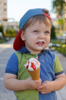 Sevimli küçük çocuk bir Dondurma külahı çilek reçeli ile tutarak 