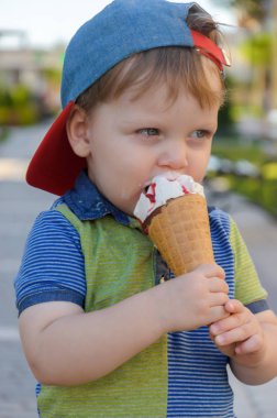 Sevimli küçük çocuk bir Dondurma külahı çilek reçeli ile tutarak 