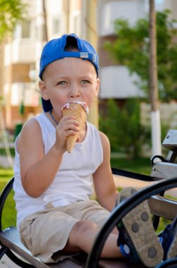 Mavi bir kap ve bir beyaz çocuk T-shirt bir Ice cream mahkûm yiyor