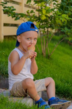 NasıIsın üzerinde oturan bir Dondurma külahı yeme dalgın küçük çocuk