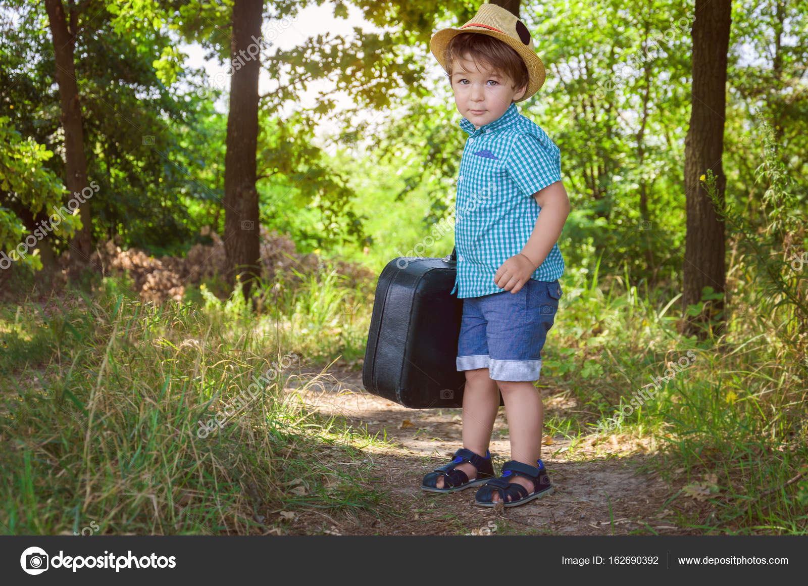 solide Wiens Dakloos Kleine jongen in een plaid shirt en een stro hoed draagt een koffer ik ⬇  Stockfoto, rechtenvrije foto door © Dudaeva #162690392