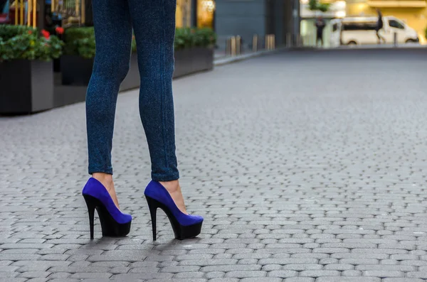 Όμορφο λεπτό τα πόδια γυναίκα στο στενό τζιν και μπλε παπούτσια σε ένα — Φωτογραφία Αρχείου