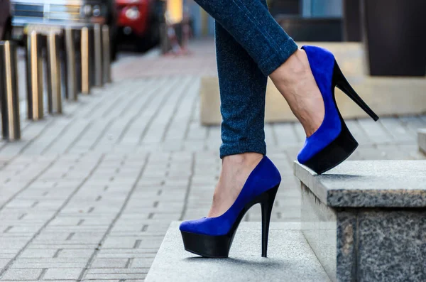 Beautiful slender female legs in tight jeans and blue velvet hig — Stock Photo, Image