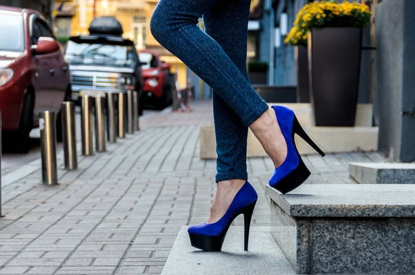 Красиві стрункі жіночі ноги в вузьких джинсах і блакитному оксамиті високо — стокове фото