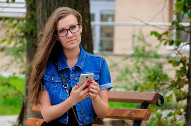 Güzel ince Kız bardaklarda oturur parkta bir bankta bir