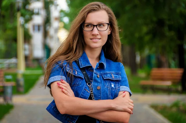 Vacker kvinna i en kort svart klänning och glasögon promenader i den — Stockfoto