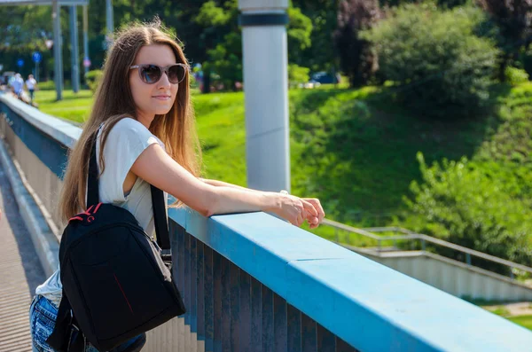 Красивая стройная стильная студентка стоит на мосту — стоковое фото