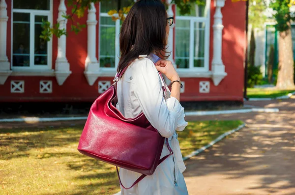 Slim wanita bergaya dalam jubah putih dengan tas burgundy — Stok Foto