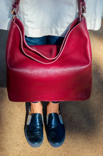 Elegante donna alla moda tiene una borsa in pelle — Foto Stock