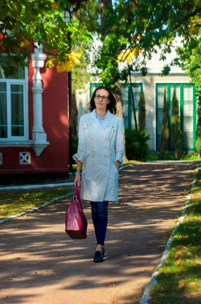 Bordo bir çanta ile beyaz bir pelerin ince şık kadın 