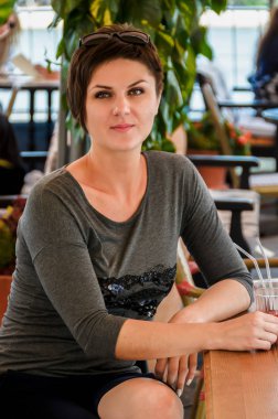 Kısa saç modeli ile güzel kadın oturur bir yaz terasında bir 