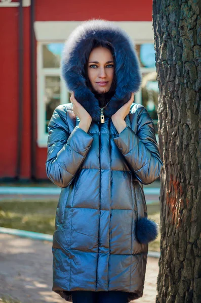 Bruneta žena stojí pod stromem v parku vedle červený dům — Stock fotografie