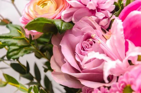 Delicate fresh bouquet of fresh flowers with a pink rose.