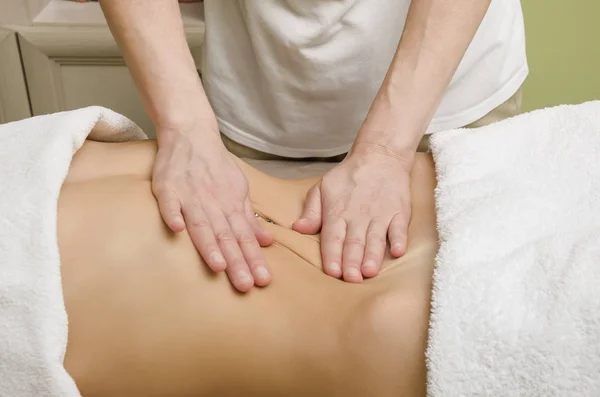 Ontspannende professionele massage op de vrouwelijke buik in de salon — Stockfoto