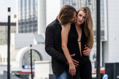 Klasik elbiseler zarif çekici çift bir kentsel şehir (taş orman fonunda hugs)