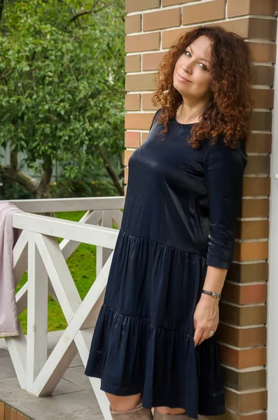 Aantrekkelijke curly-haired roodharige vrouw voor veertig jaar standin — Stockfoto