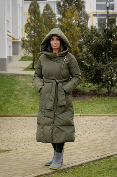 Привлекательная женщина в зеленой зимней куртке и шляпе с модой — стоковое фото