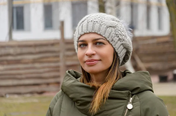 Attraktiv kvinna i en grön vinterjacka och hatt med en mode — Stockfoto