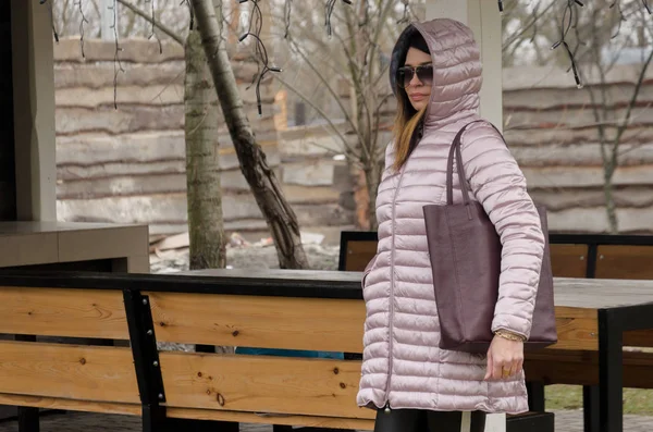 Atractiva mujer está de pie en un invierno acolchado chaqueta rosa nea — Foto de Stock