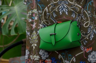 Bir fashionista elinde zarif küçük yeşil deri çanta. 