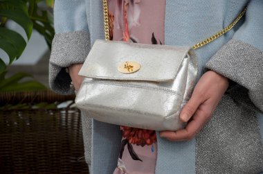 bir fashionista elinde zarif küçük Gümüş deri çanta. 