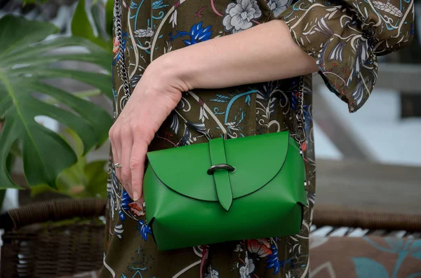 Елегантна маленька зелена шкіряна сумка в руках модниці . — стокове фото