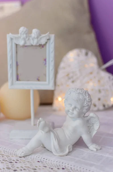 Beautiful carved frame for photos and an angel statue on the tab — Stock Photo, Image