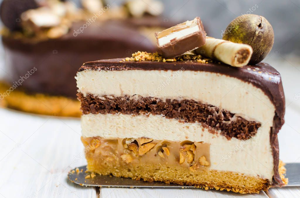 Delicious chocolate cake with biscuit, mousse layers, sweets and