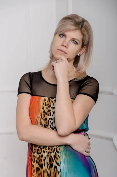 Porträtt av en söt blond kvinna i en vacker färgad klänning. CLA — Stockfoto