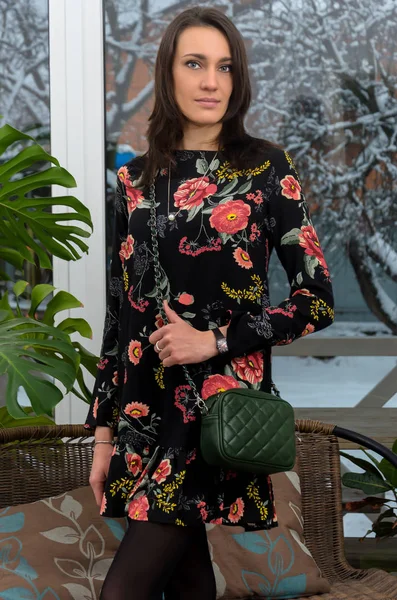 Krásná žena v moderní trendy šaty s květinovým potiskem v ústředně — Stock fotografie