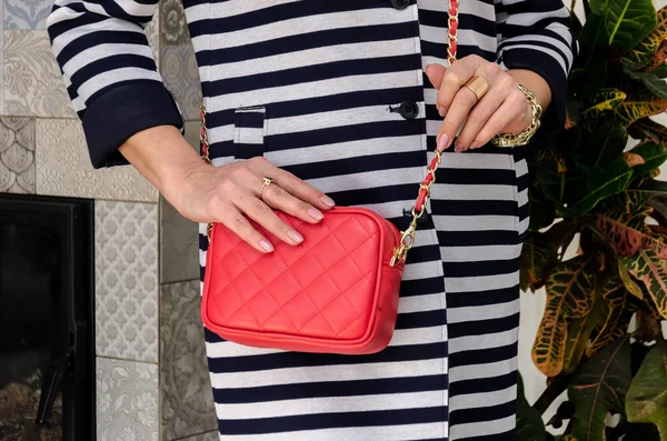 Женщина держит небольшую стильную сумку (сцепление) ярко-красного цвета остроумия — стоковое фото