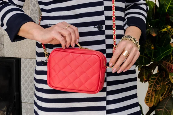 Frau hält eine kleine stylische Tasche (Clutch) von leuchtend roter Farbe Witz — Stockfoto
