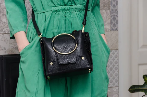 Stylish woman with a fashionable woman has a small black bag (cl — Stock Photo, Image