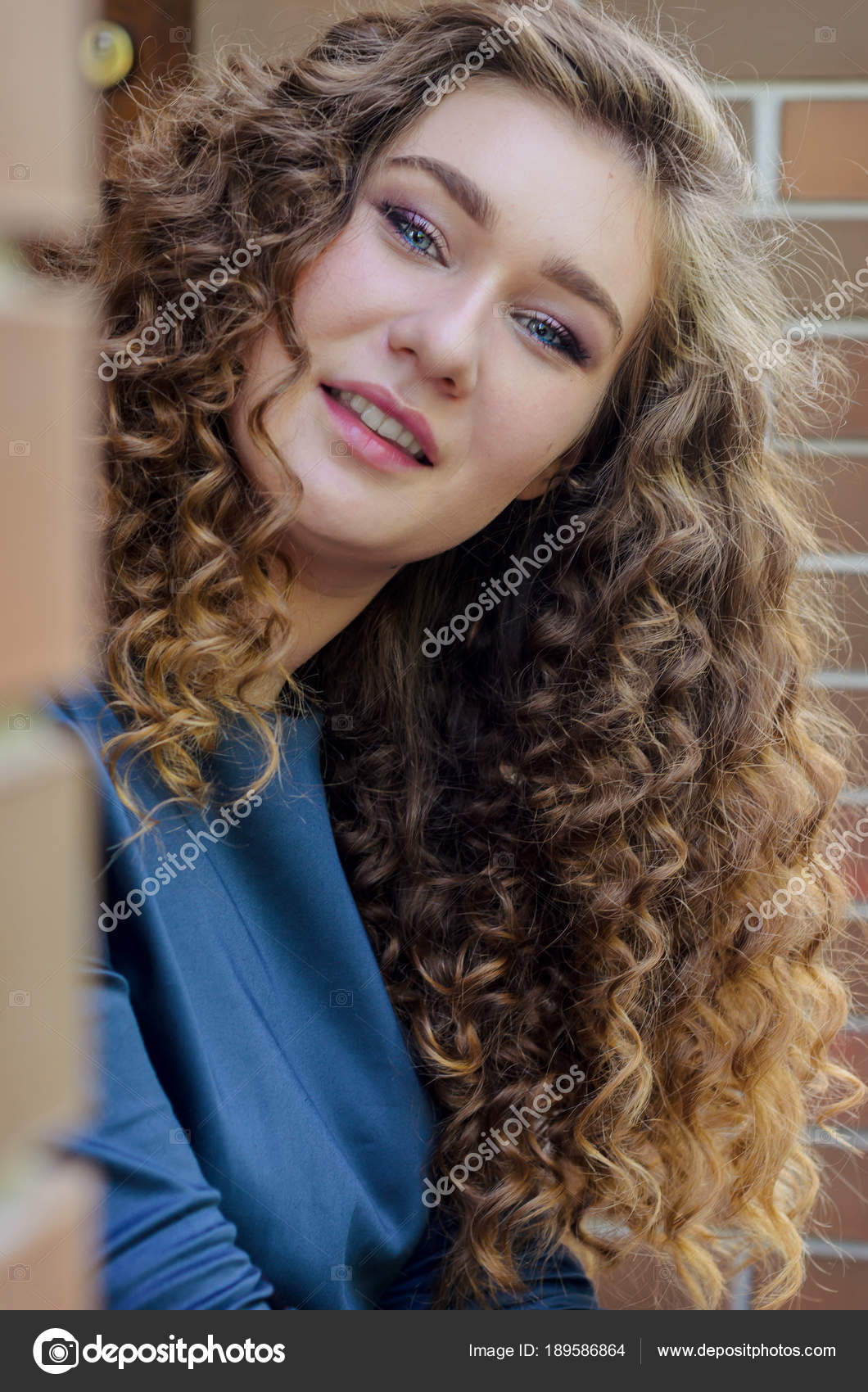 Portrait Of A Beautiful Cute Girl With Chic Curly Hair Against A