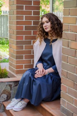 uzun gri elbise ve bir ışık şık kıvırcık saçlı güzel kadın