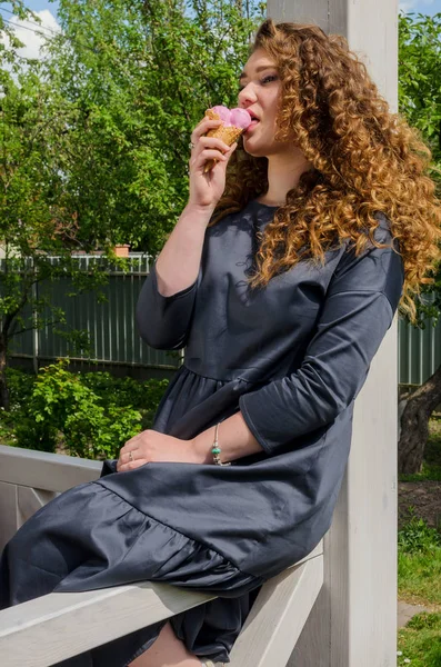 Donna elegante con capelli ricci chic mangiare gelato in tribunale — Foto Stock