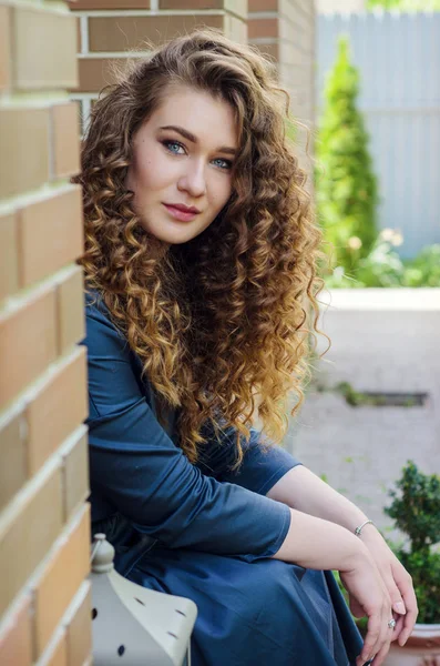 Portrait of a beautiful cute girl with chic curly hair against a — Stock Photo, Image