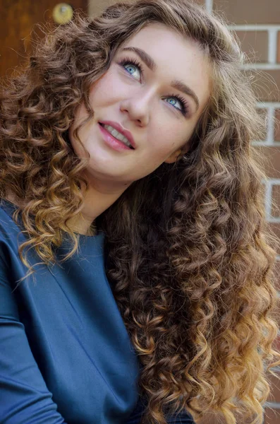 Portrait of a beautiful cute girl with chic curly hair against a — Stock Photo, Image