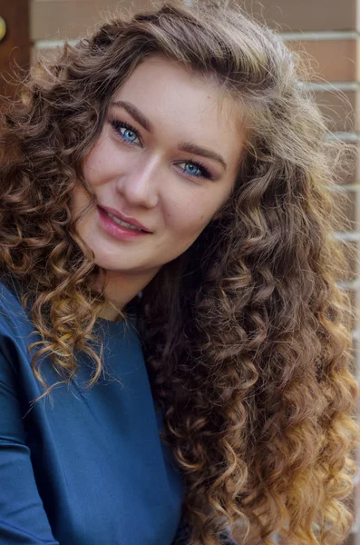 Retrato de uma linda garota bonita com cabelo encaracolado chique contra um — Fotografia de Stock