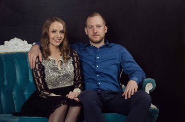 Güzel aşık genç Çift Klasik giysiler içinde bir blu üzerinde oturur