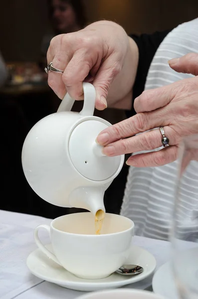 Руки взрослой (пожилой) женщины (бабушки) залить чай из — стоковое фото