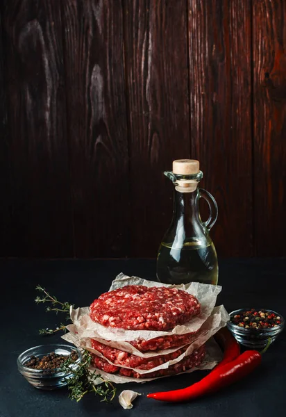 Carne picada cruda fresca para albóndigas con especias en un respaldo negro — Foto de Stock