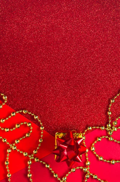 Three shades of red with festive sequins and a golden gift box a — Stock Photo, Image