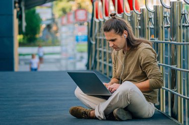 Şehirde bilgisayar başında çalışan çekici stil düşkünü bir hippi.